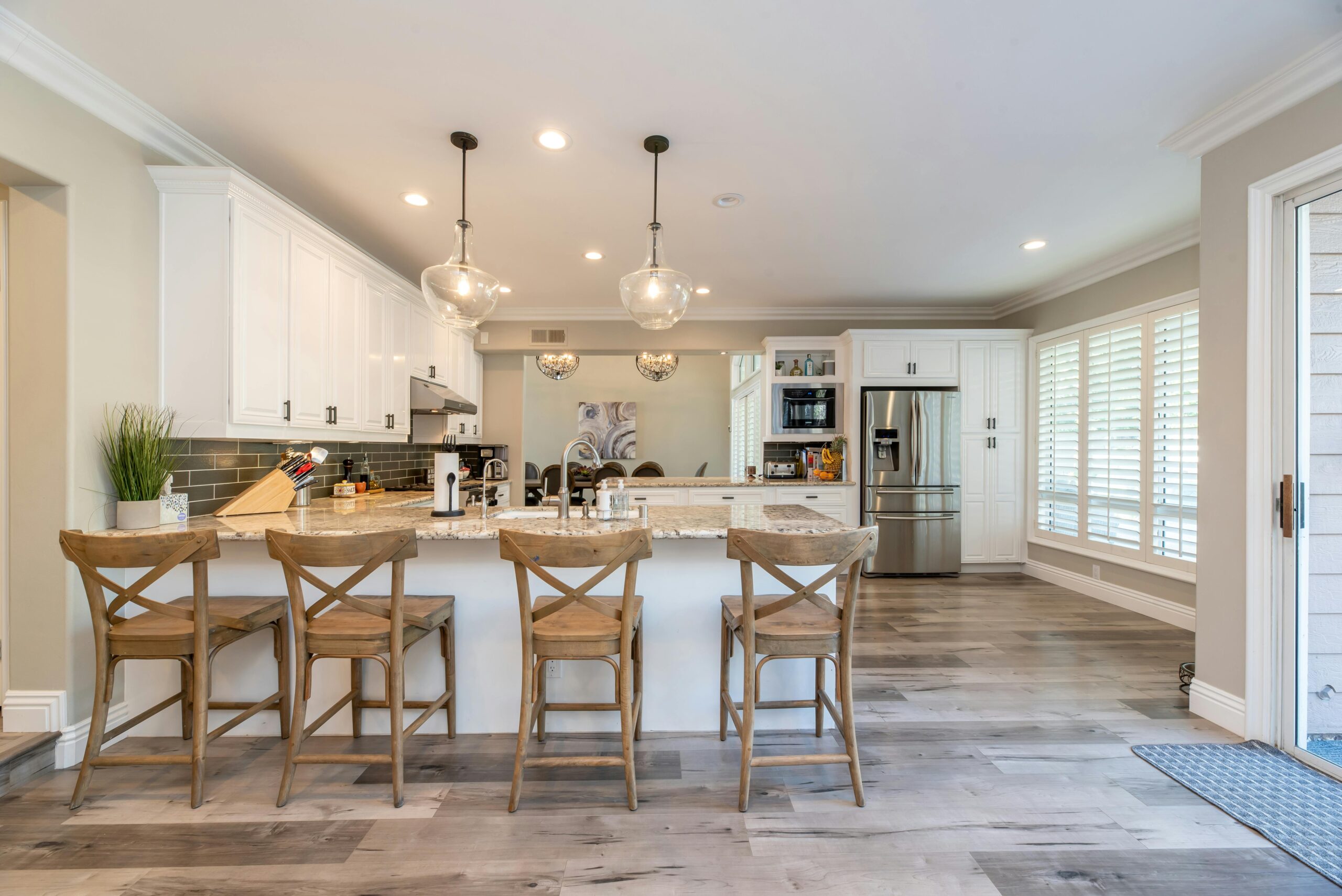 Modern open plan kitchen with breakfast bar seating, white cabinetry and spacious layout for family living